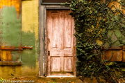 An old wooden door on an old building in an alley way.