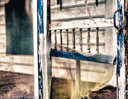 An old screen door on a screened-in porch of an old house.