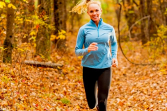 Woman dressed in fitness clothing running in a forest in autumn. Woman dressed in fitness clothing running in a forest in autumn.
