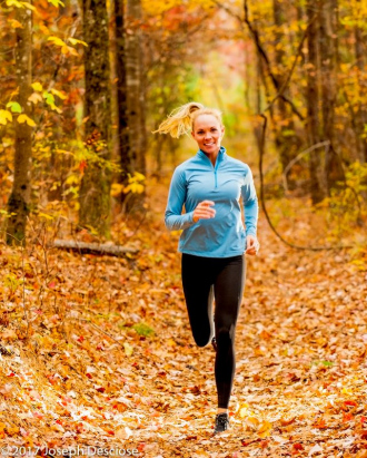 Woman dressed in fitness clothing running in a forest in autumn. Woman dressed in fitness clothing running in a forest in autumn.