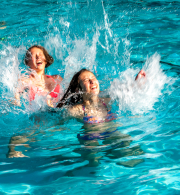 Teenagers playing in a swimming pool.