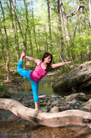 Young brunette woman doing yoga poses in a forest setting in the springtime.