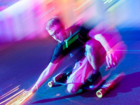 Rollerboarding through a lighted traffic tunnel.