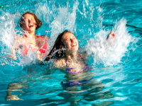 Teenagers playing in a swimming pool.