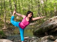 Young brunette woman doing yoga poses in a forest setting in the springtime.